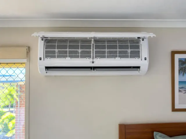 Clean split system with open front panel and visible filters on a beige wall in a home in Miami