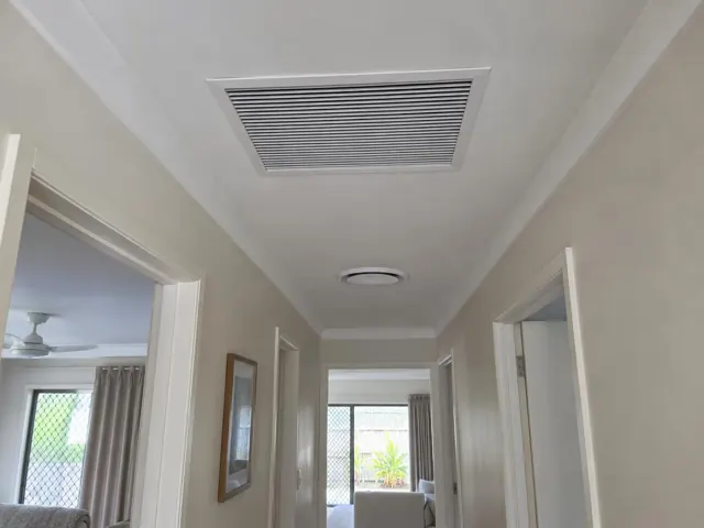 Ceiling return-air grille in a hallway with doorways and light walls in Mermaid Beach